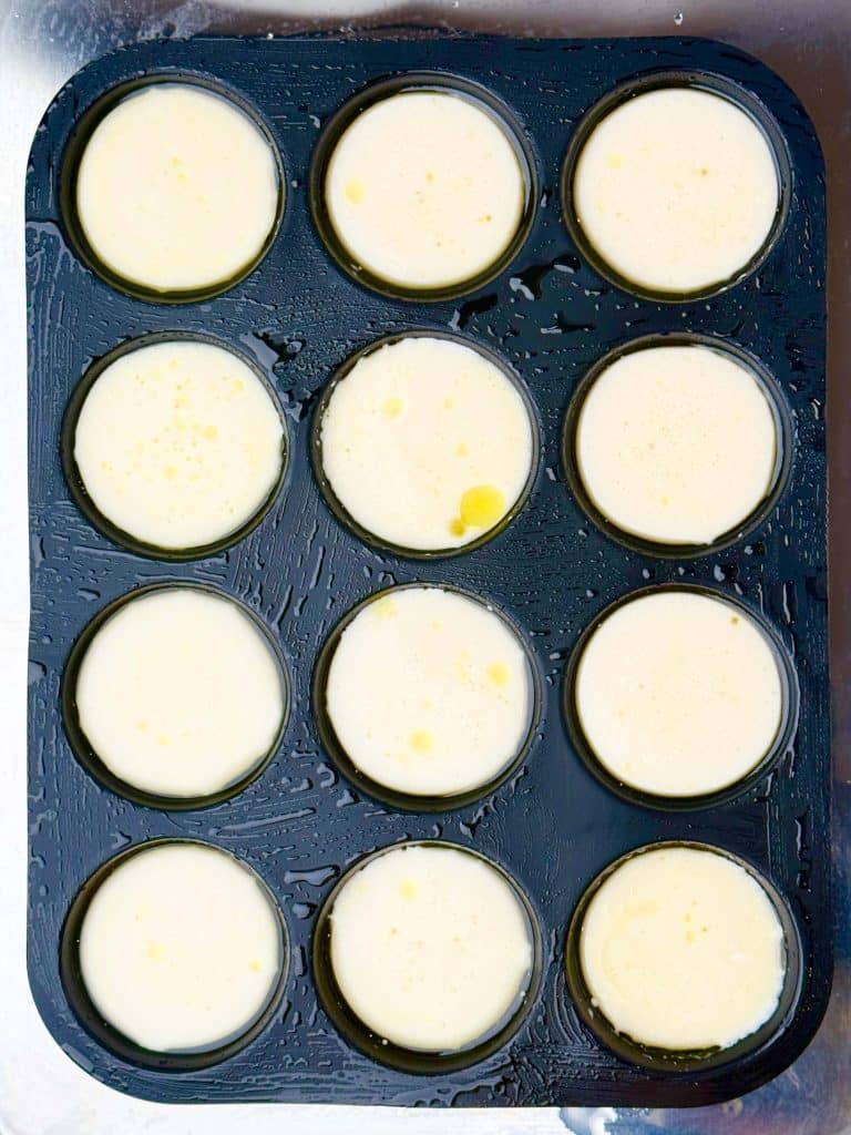 Smooth blended egg white mixture portioned into muffin tin for copycat Starbucks egg white bites before adding toppings.