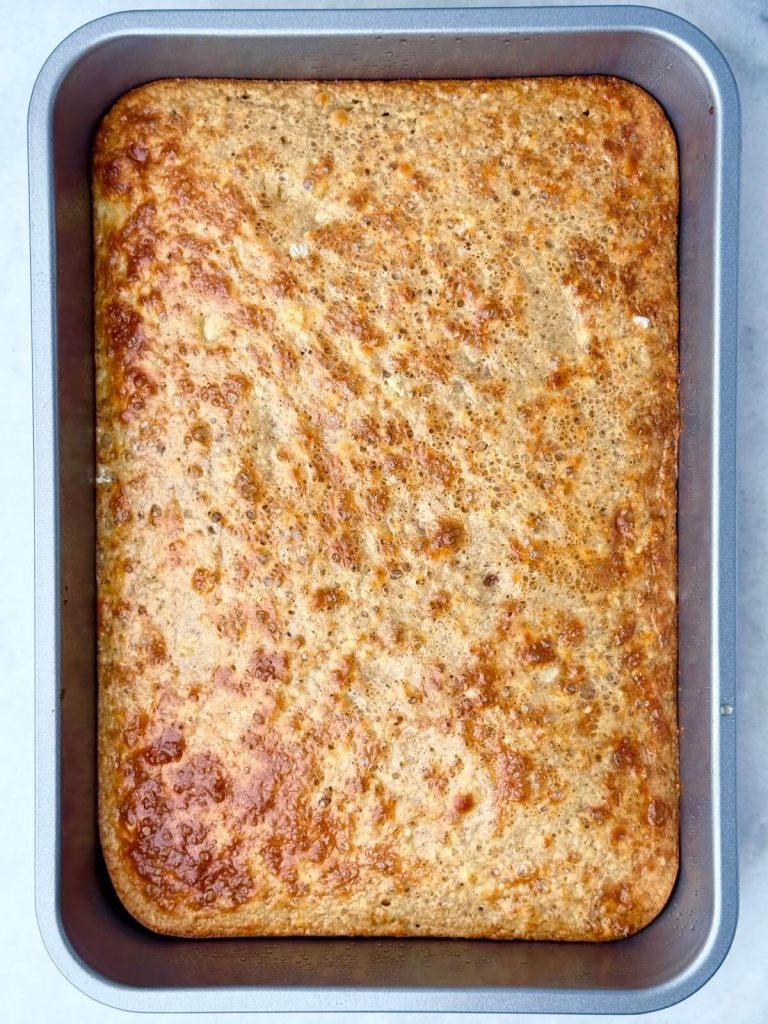 Golden sheet pan banana protein pancakes baked in a 9x13 dish, ready to slice and serve.