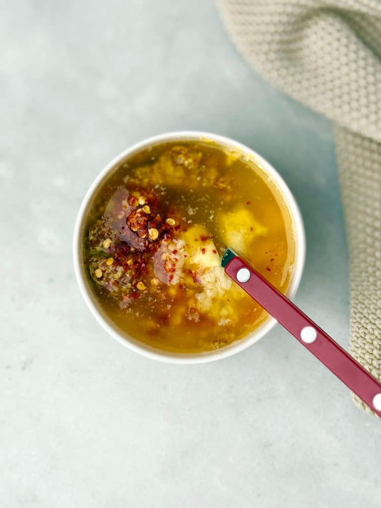 Maple mustard butter sauce for fall sausage and veggie sheet pan dinner with chili flakes and garlic.