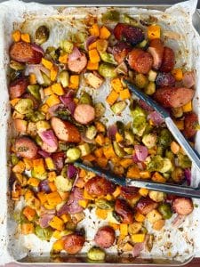 Caramelized fall sausage and veggie sheet pan dinner after roasting, ready to serve with maple mustard glaze.