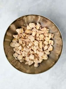 Bowl of chopped cooked chicken breast ready for curry chicken salad.