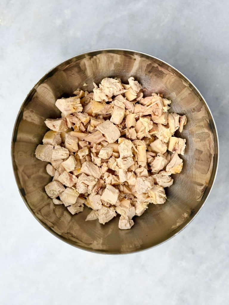 Bowl of chopped cooked chicken breast ready for curry chicken salad.