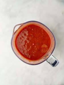 Smooth red chili sauce in blender for homemade crockpot birria soup.