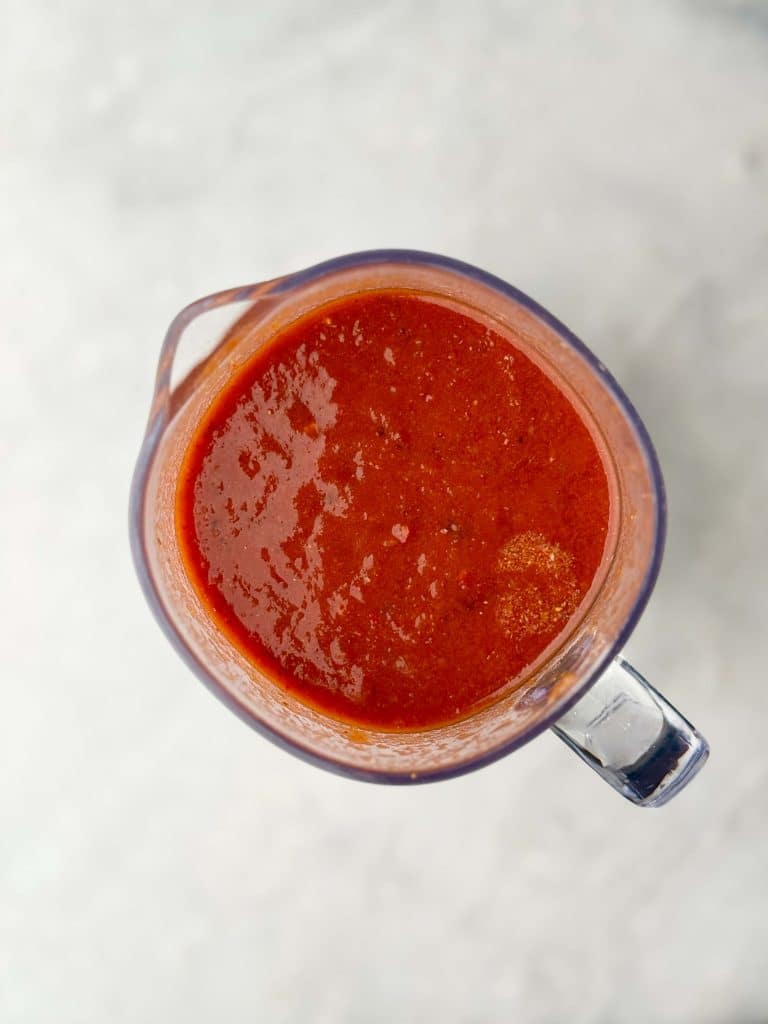 Smooth red chili sauce in blender for homemade crockpot birria soup.