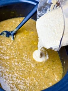 Blended cottage cheese being poured into broccoli cheddar soup