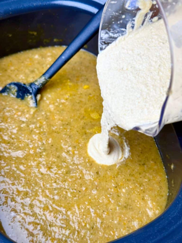 Blended cottage cheese being poured into broccoli cheddar soup