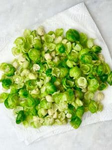 Blanched Brussels sprouts leaves drying on a paper towel.