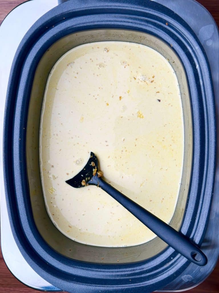 Crockpot spiced chickpea stew with coconut milk and turmeric base simmering in slow cooker.