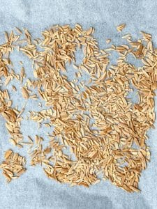 Oven-toasted almond slivers cooling on a parchment-lined baking sheet.