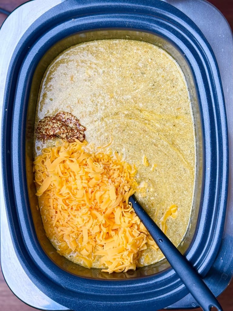 Cheddar cheese and grainy mustard added to crockpot broccoli cheddar soup