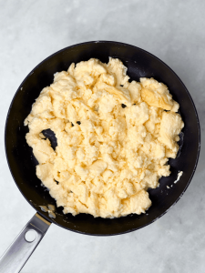 Fluffy scrambled eggs made with eggs, egg whites, and cottage cheese in a nonstick skillet for high protein freezer breakfast burritos.