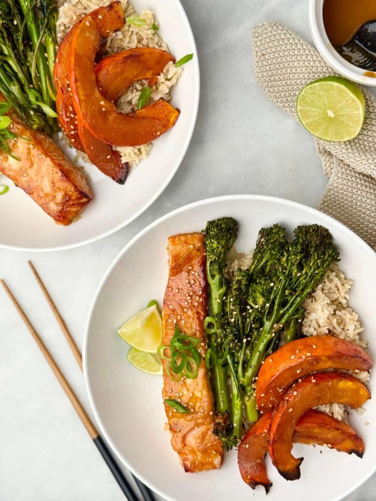 Miso glazed salmon bowl with roasted kabocha squash, broccolini, and brown rice, topped with sesame seeds and scallions