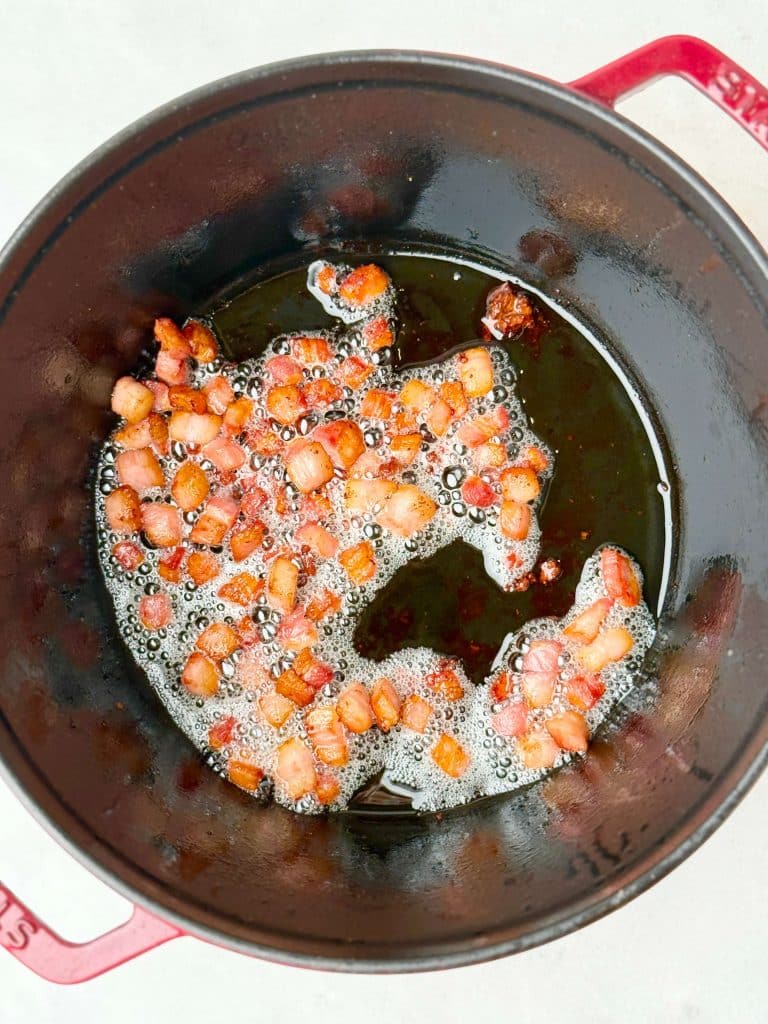 Diced bacon cooking until crisp for braised red cabbage with sausage