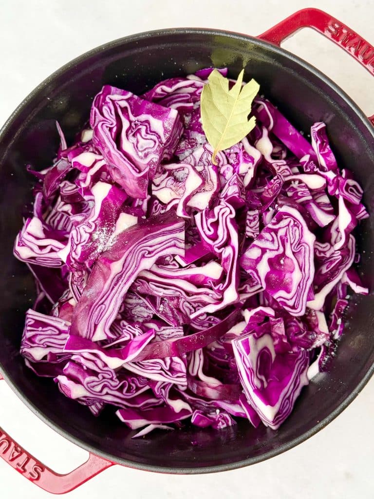 Freshly sliced red cabbage with bay leaf ready to braise in German-style red cabbage recipe