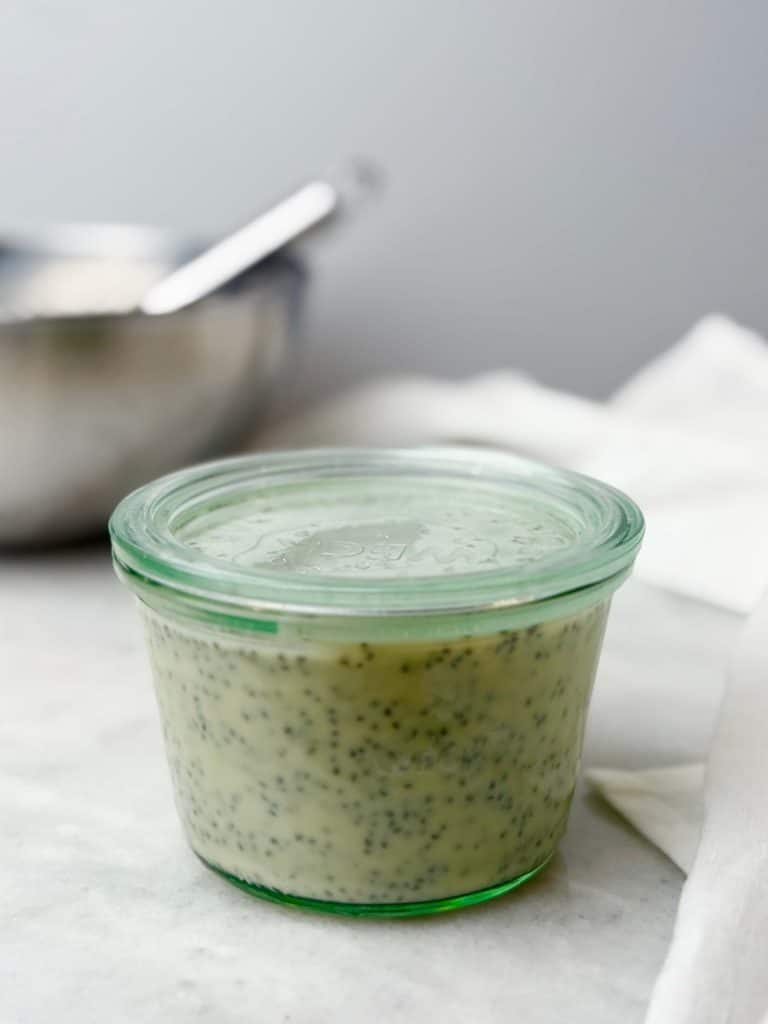 Glass jar filled with freshly mixed dairy free chia seed pudding before refrigerating to set.