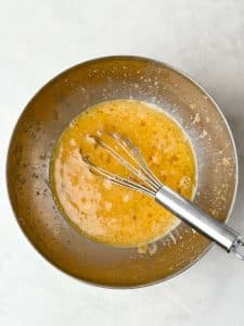 Whisked eggs and egg whites in a stainless steel mixing bowl for veggie-loaded breakfast frittata cups