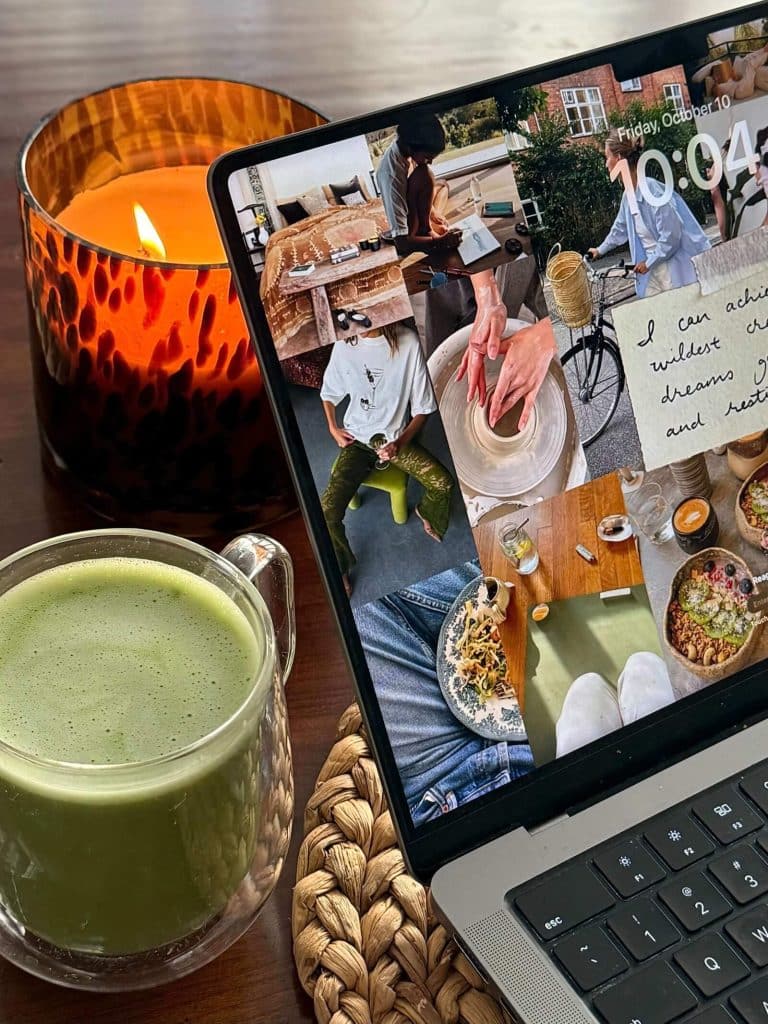 Digital vision board displayed on a laptop beside a candle and matcha latte, representing intentional goal setting.