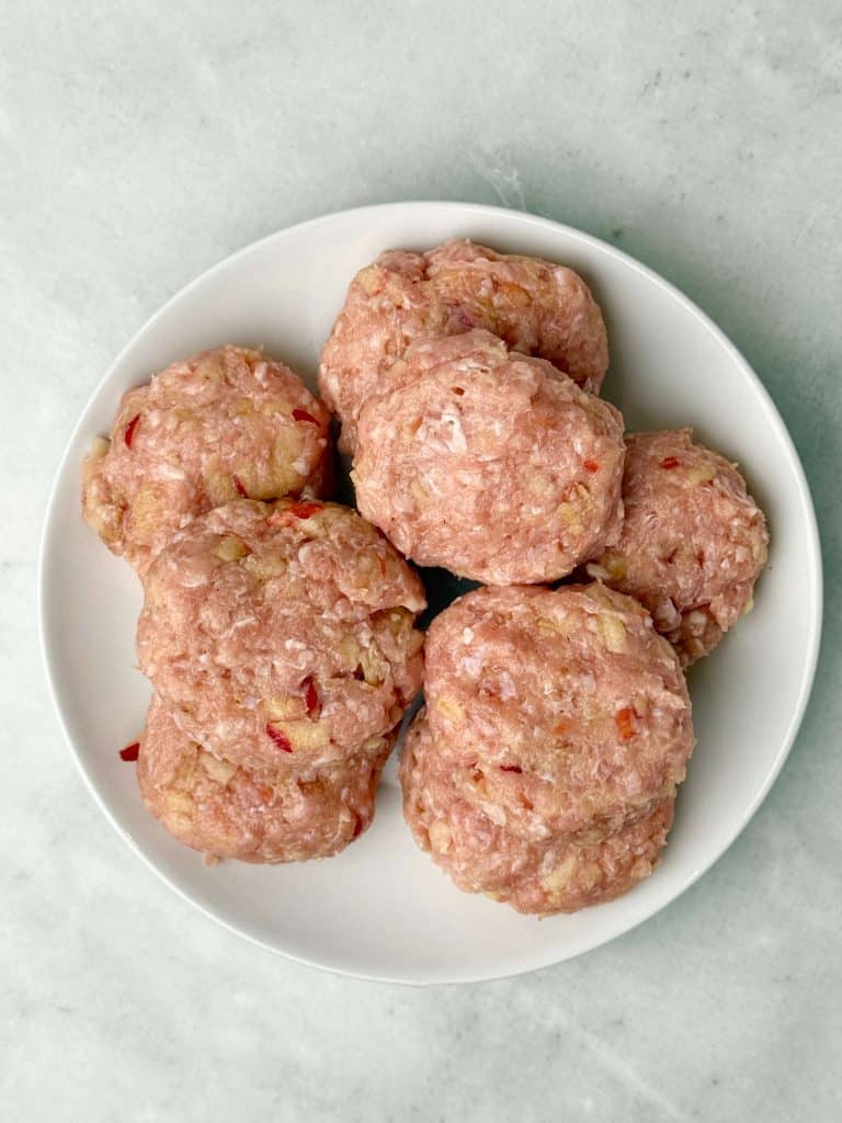 Uncooked chicken apple sausage patties shaped and ready for the skillet