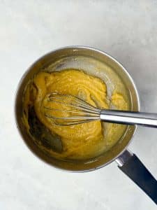Butter and flour whisked together in a saucepan to make a golden roux for creamy béchamel sauce.