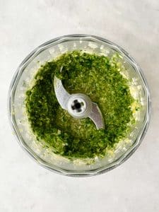 Fresh herb and garlic mixture blended in a food processor for oven roasted spatchcock chicken.