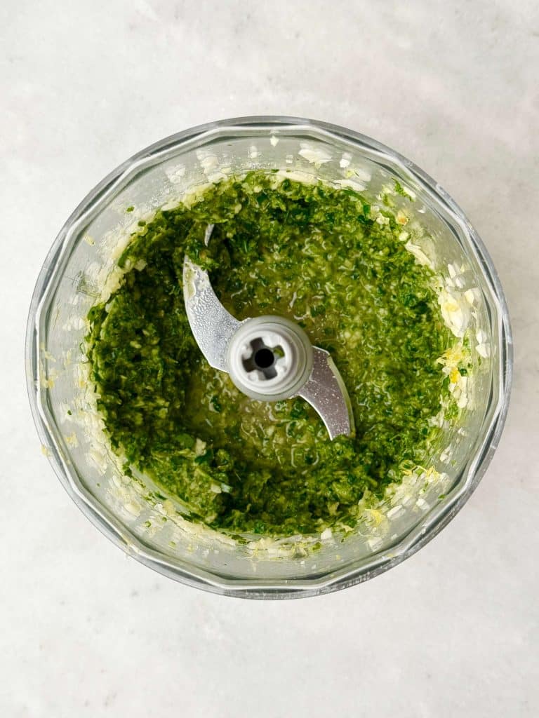 Fresh herb and garlic mixture blended in a food processor for oven roasted spatchcock chicken.