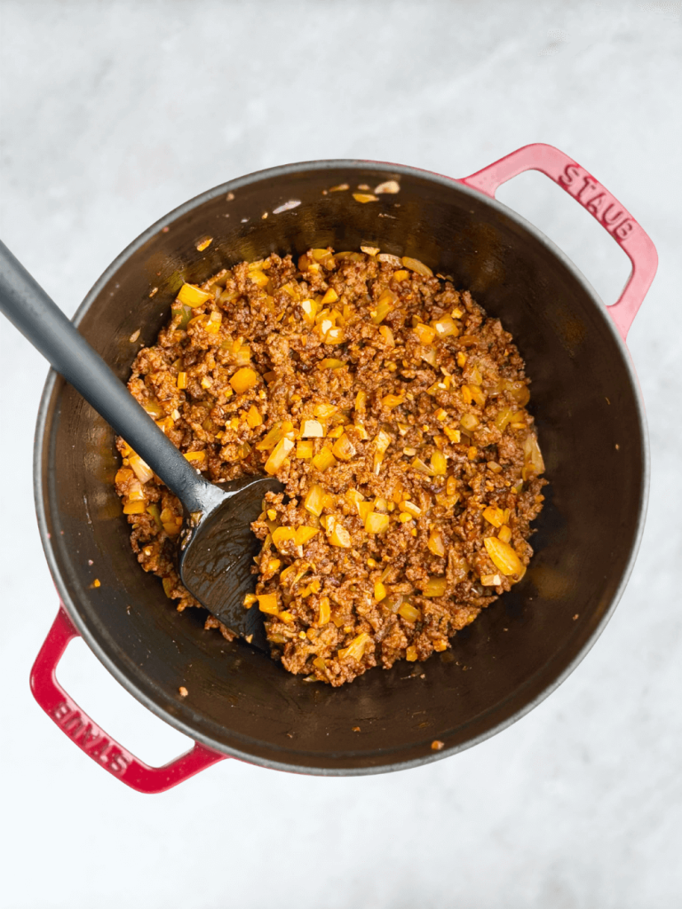 Ground beef browned with onions and tomato paste to build the base of creamy lasagna soup.