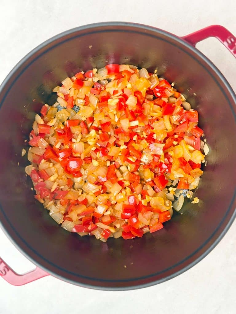 Sauteed onion and red bell pepper in a Dutch oven for high protein low calorie turkey chili.
