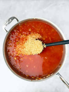 Adding orzo into the tomato broth for a hearty one-pan Mediterranean seafood dinner.