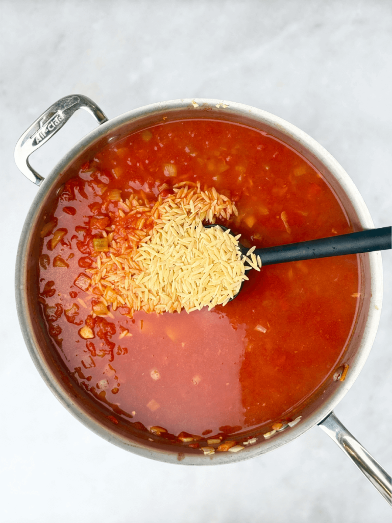 Adding orzo into the tomato broth for a hearty one-pan Mediterranean seafood dinner.