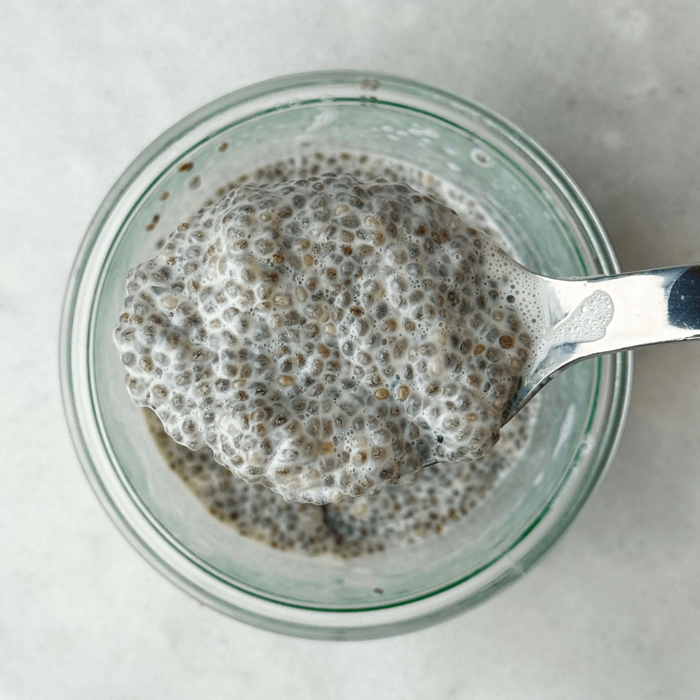 Thick and creamy dairy free chia seed pudding shown on a spoon with a rich, mousse-like texture.