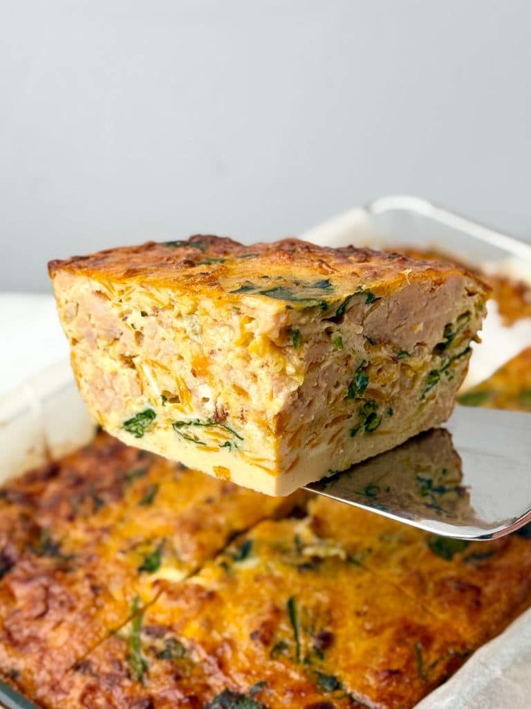 Thick slice of dairy-free breakfast casserole with sausage, sweet potato, and spinach.