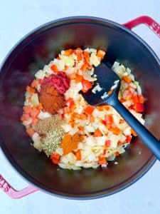 Sautéed onions and red bell peppers with tomato paste and warm spices forming the flavor base for high-protein black bean soup.