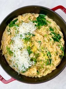 Stirring parmesan, fresh dill, lemon zest, and spinach into creamy lemon chicken orzo.