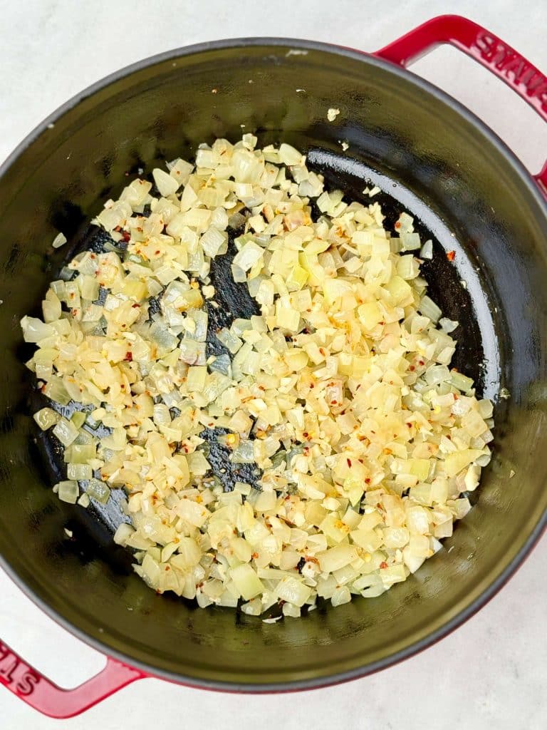 Sautéed onion, garlic, and crushed red pepper in a Dutch oven as the base for lemon chicken orzo.
