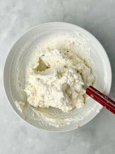 Bowl of whipped lemon ricotta topping made with ricotta, Parmesan, and lemon zest for white lasagna soup.