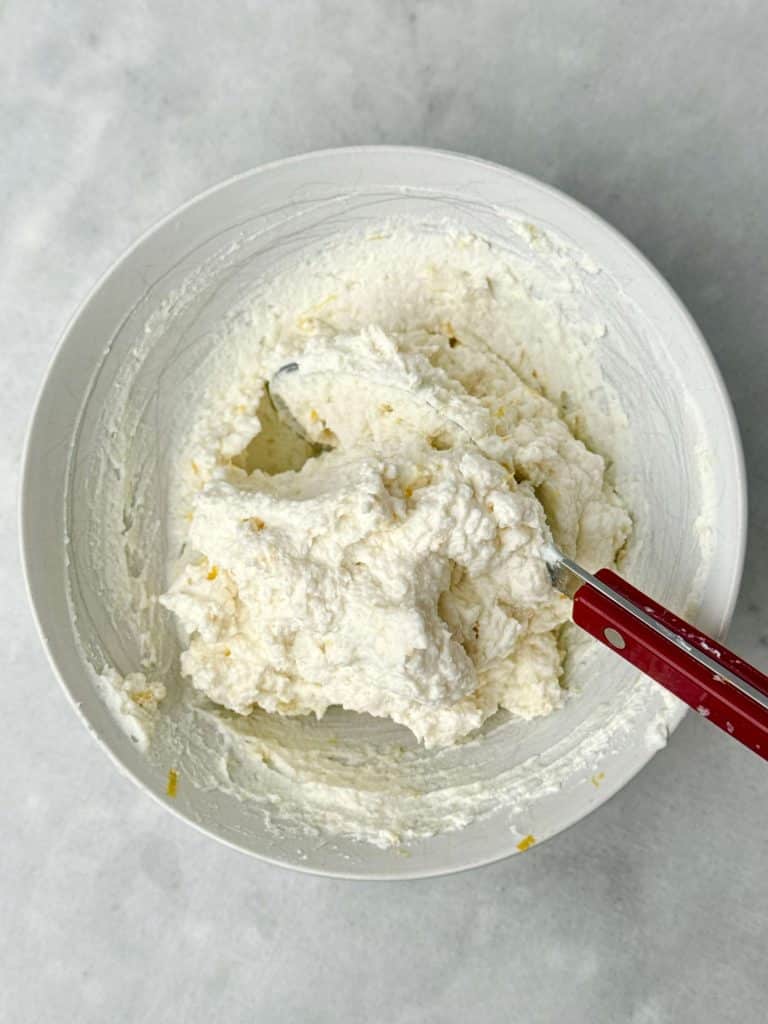 Bowl of whipped lemon ricotta topping made with ricotta, Parmesan, and lemon zest for white lasagna soup.