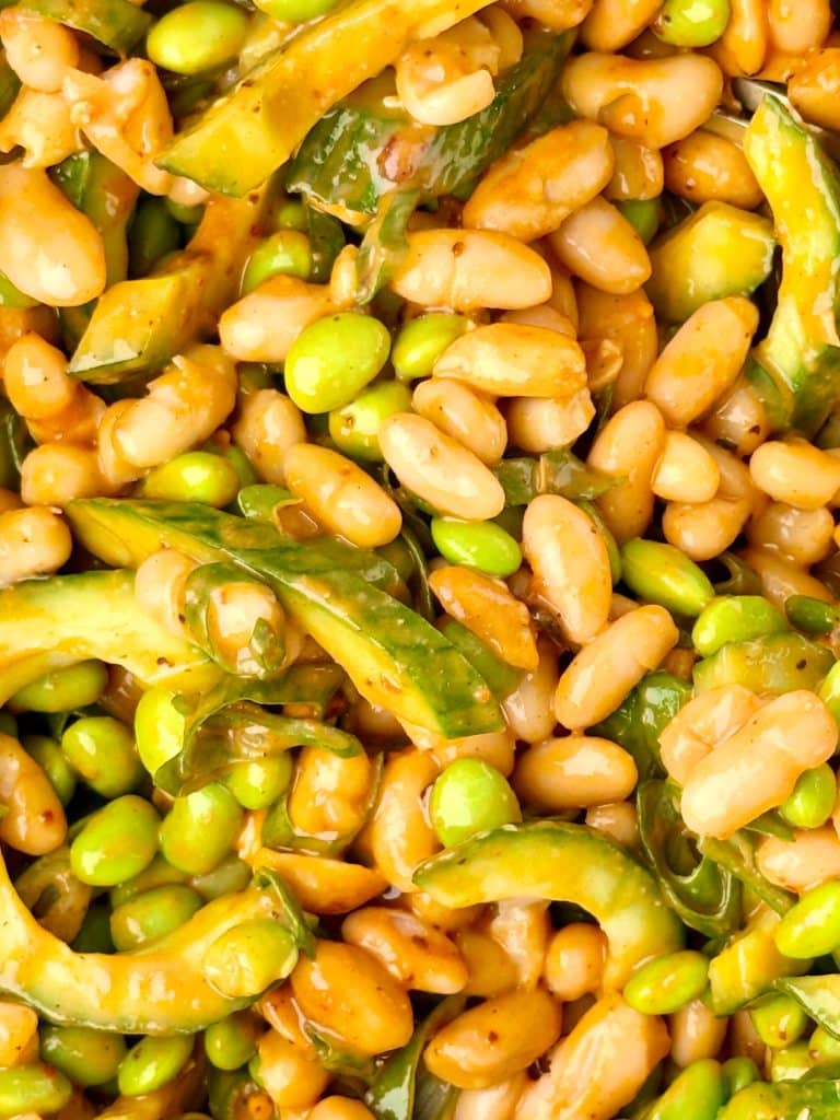 Asian-inspired dense bean salad with white beans, edamame, cucumber, peanuts, and spicy peanut miso dressing.