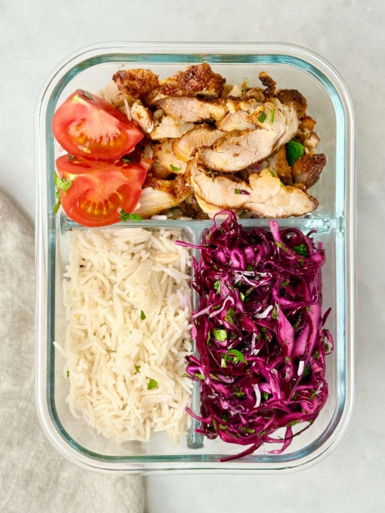 High-protein chicken shawarma meal prep with air fryer chicken, rice, and red cabbage salad in a glass container.