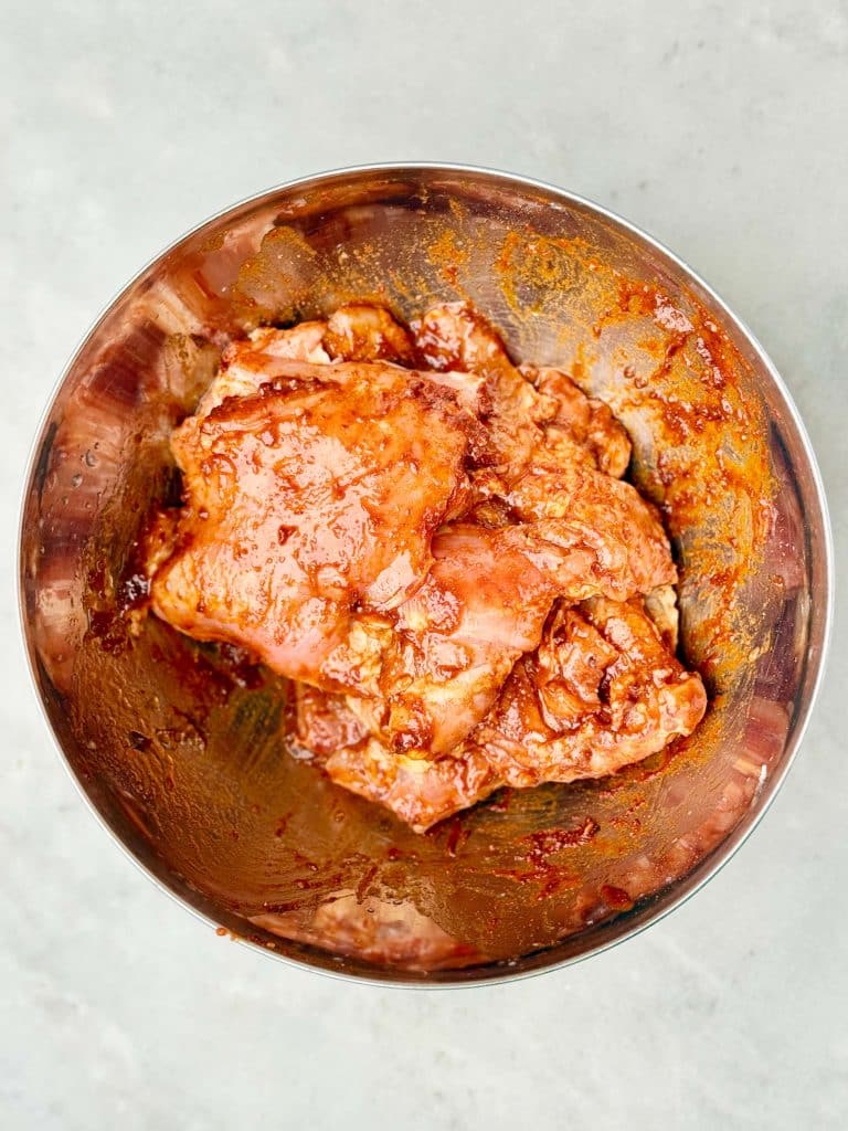 Chipotle-marinated boneless skinless chicken thighs coated in a smoky adobo sauce for a copycat Chipotle burrito bowl.