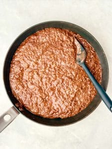 Hot chocolate protein oats cooked on the stovetop, thick and creamy chocolate oatmeal in a saucepan