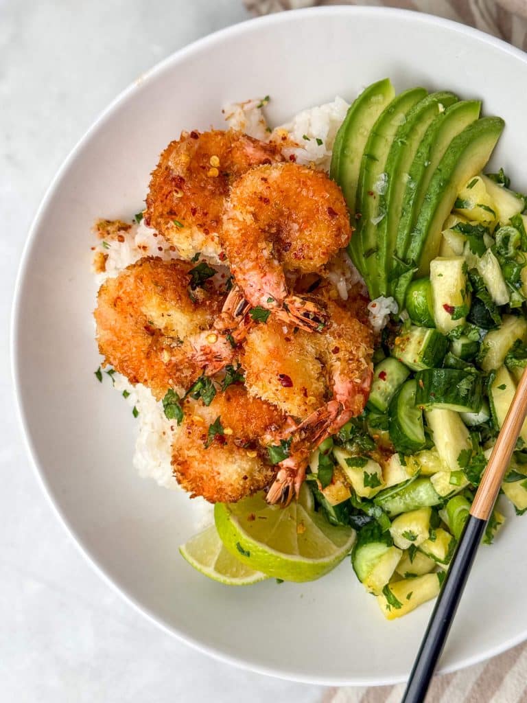 Air fryer coconut shrimp bowls served over rice with avocado, lime, and fresh pineapple salsa