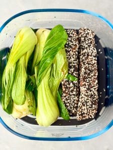 Raw sesame crusted salmon fillets and baby bok choy prepared for air frying