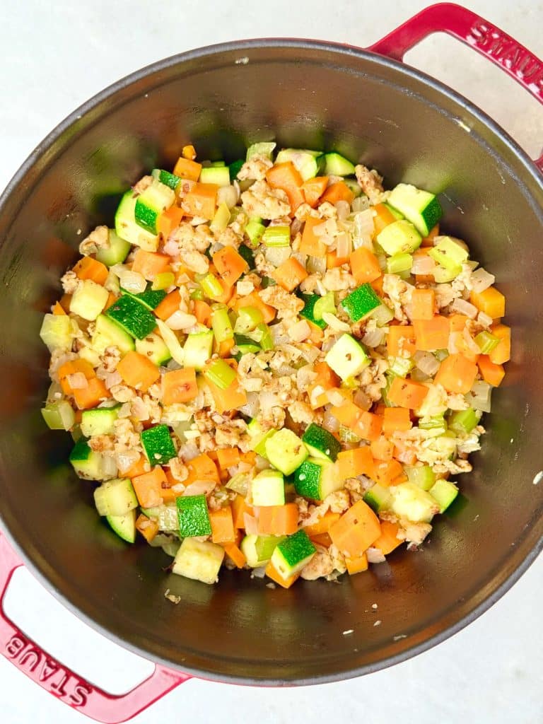 Zucchini added to chicken sausage and vegetables while making high protein minestrone soup