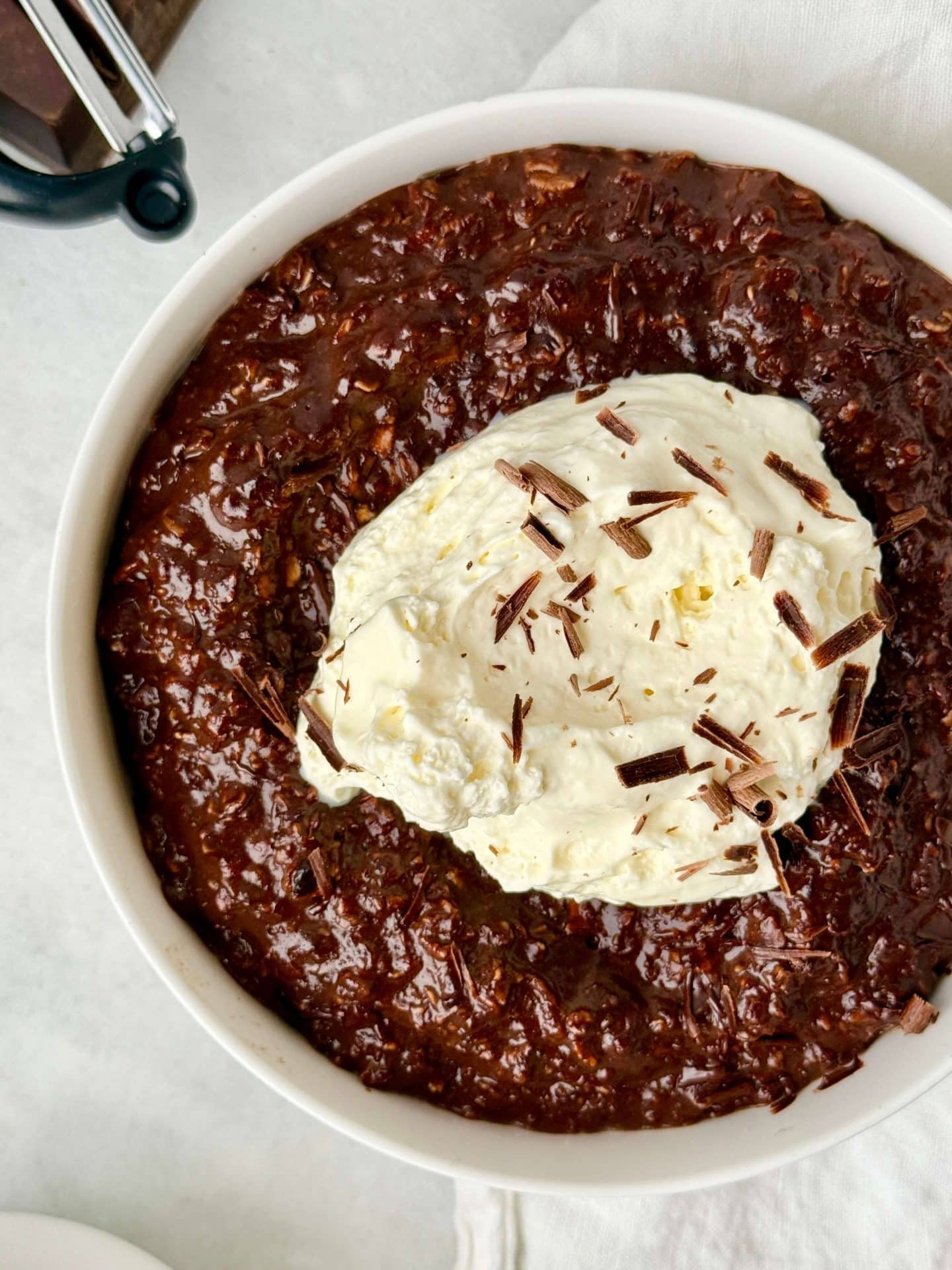 Hot chocolate protein oats served warm with a dollop of whipped cream