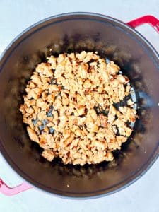 Chicken sausage browning in a Dutch oven for high protein minestrone soup