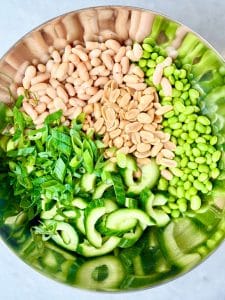 Miso dense bean salad recipe served in a bowl, topped with peanuts and sesame seeds, perfect for meal prep.