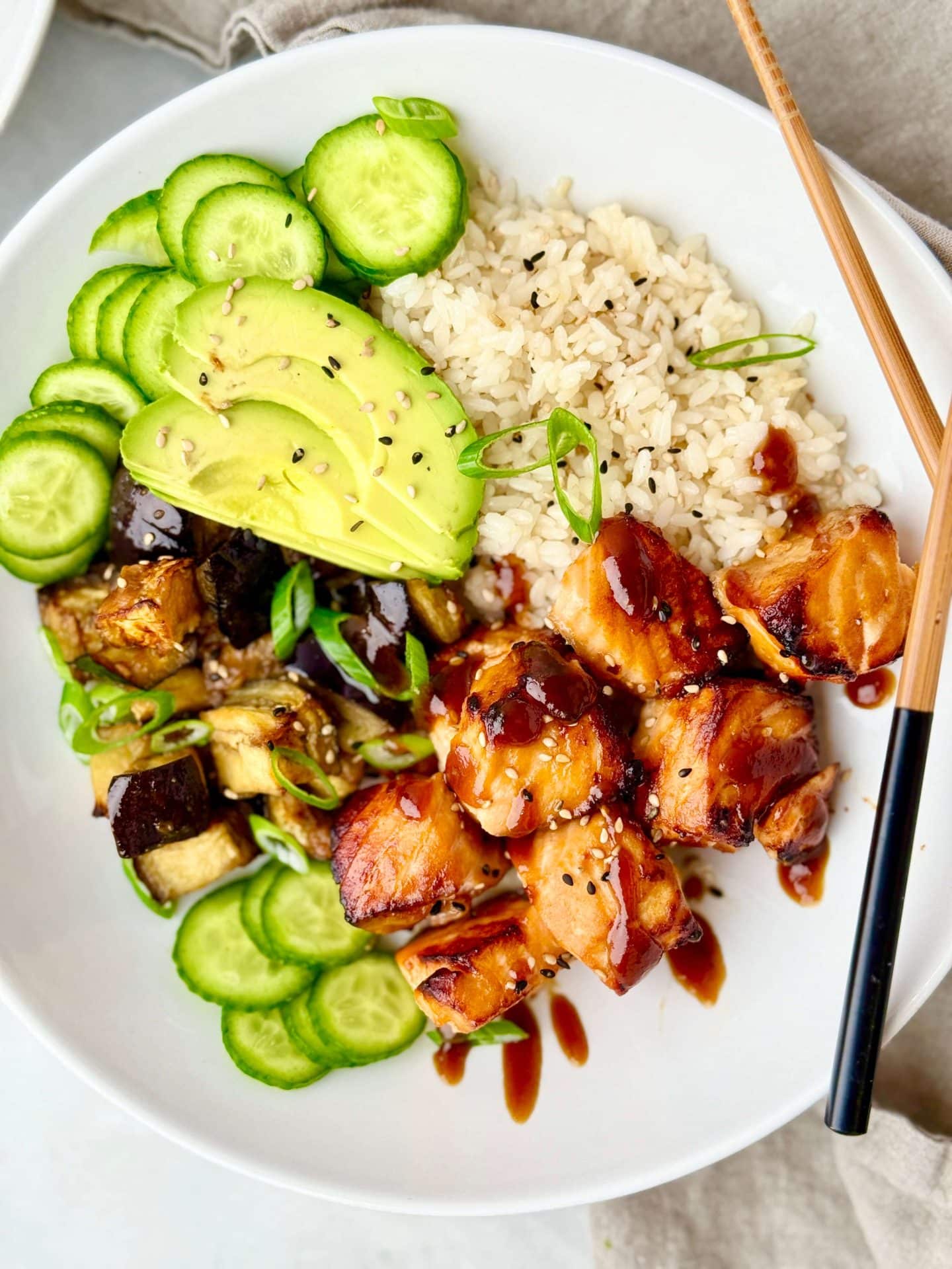 Sticky miso glazed salmon bowl with rice, edamame, and pickled cucumbers