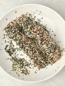 Salmon fillets coated in black and white sesame seeds before cooking