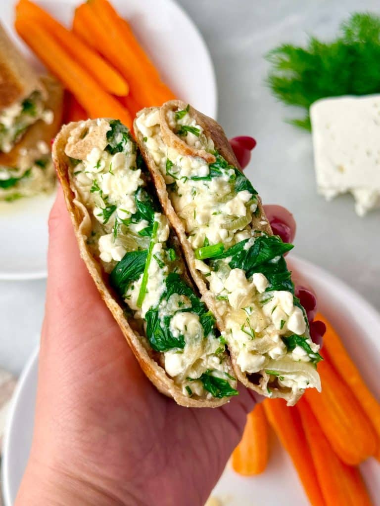 High-protein spanakopita wrap cut in half, filled with spinach, feta, and herbs