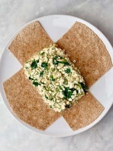 Spinach and feta filling layered onto a high-protein tortilla before wrapping